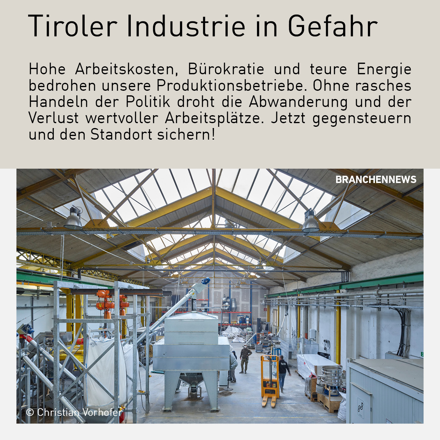 Industriehalle mit modernen Maschinen und Mitarbeitenden in Tirol, die die Herausforderungen hoher Arbeitskosten, Bürokratie und Energiekosten illustriert.