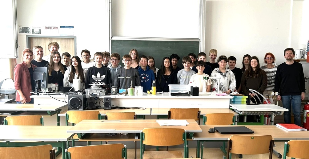 Catharina Ferencsak (WKB) (l.), Vortragender Matthias Bergthaler (3. v. l.), Direktorin Gertrud Krasny (2. v. r.) und Chemie-Lehrer Markus Halper (r.) mit an NAWI – Interessierten Schülerinnen und Schülern der 3. Klassen der MS Rosental.