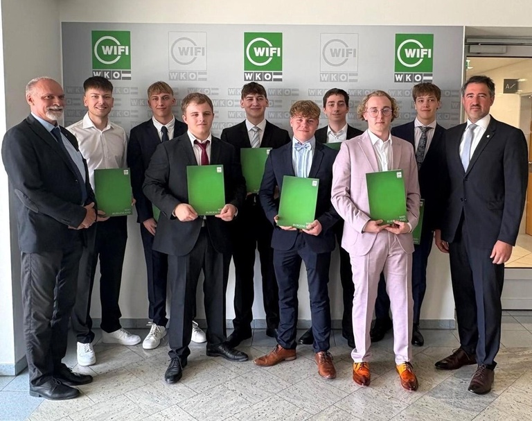 HTL-Abteilungsvorstand Michael Türk (l.) und WIFI-Institutsleiter Thomas Jestl (r.) mit den Lehre-mit-Matura-Absolventen 2025. 