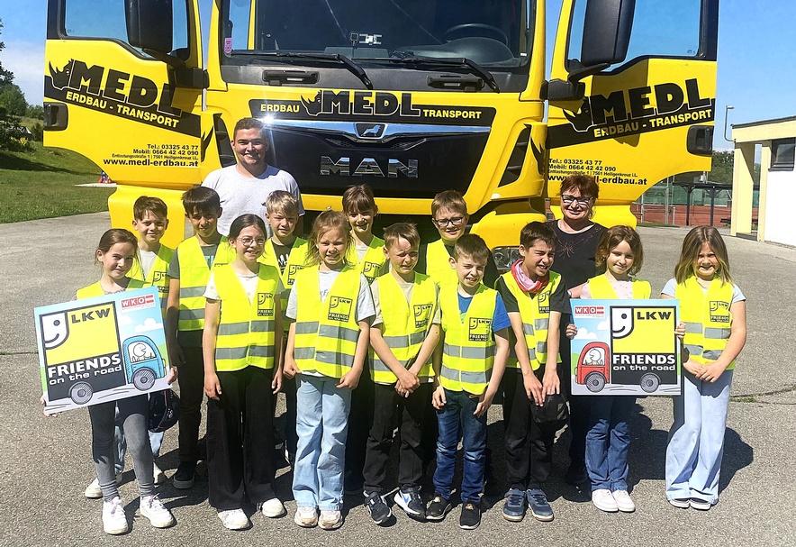 Direktorin Claudia Kröpfl-Kögl und LKW-Fahrer Jonas Panner mit den Kindern der 3. Klasse der Volksschule St. Martin an der Raab