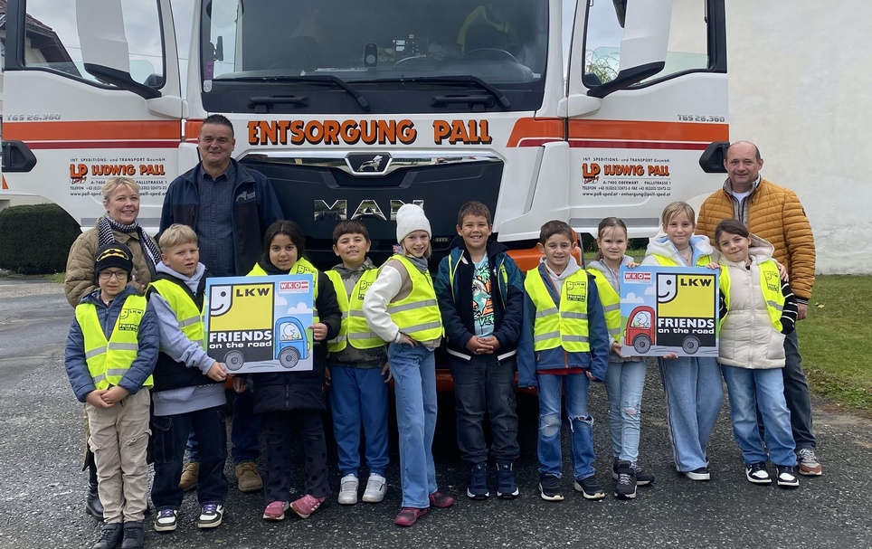 Klassenlehrerin Ursula Pasch, LKW-Fahrer Peter Varga und Direktor Wilhelm Miklos mit den Kindern der 3. und 4. Klasse der Volksschule Siget 