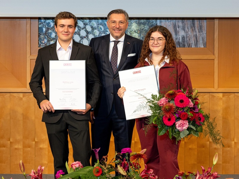 Wirtschaftskammerdirektor Harald Schermann (M.) bei der Urkundenübergabe an Matthias Lang und Julia Parapatits 