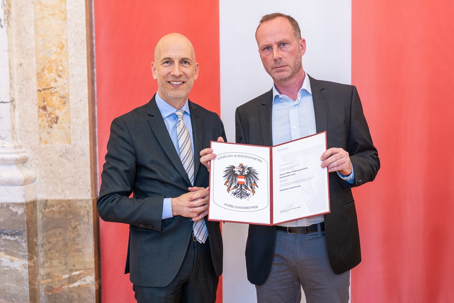 Bundesminister Martin Kocher (l.) überreicht an Joachim Tiefenbacher (r.) die Urkunde zum "Staatlich ausgezeichneten Ausbildungsbetrieb" für die Firma Johann Offner Werkzeugindustrie Gesellschaft m.b.H.