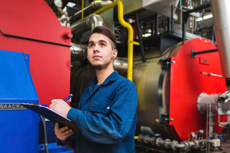 Junger Mann an Maschine