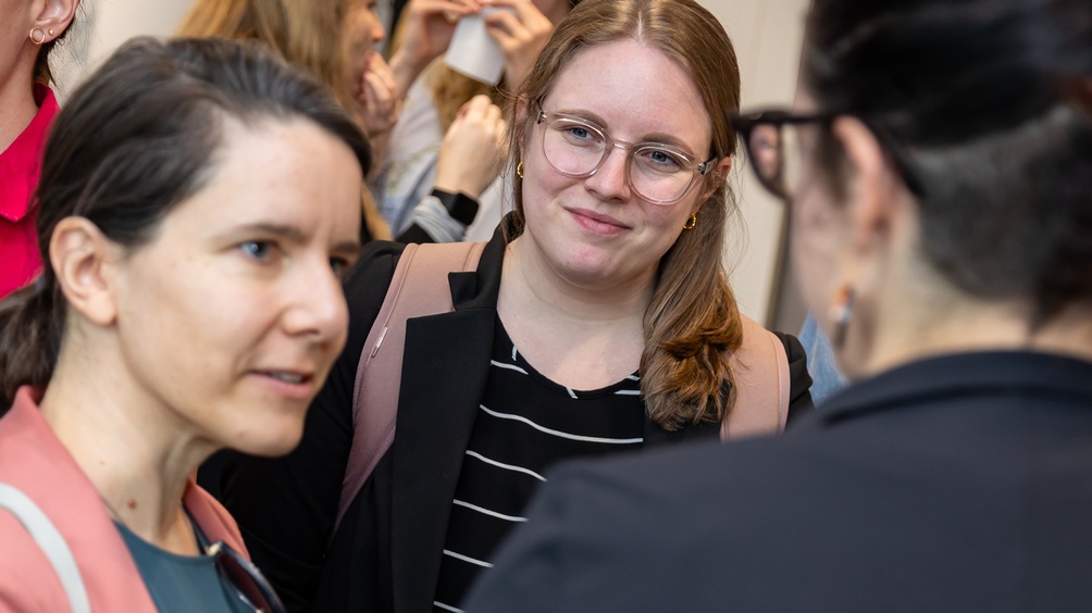 Porträt einer Person, die zwischen zwei anderen Personen steht