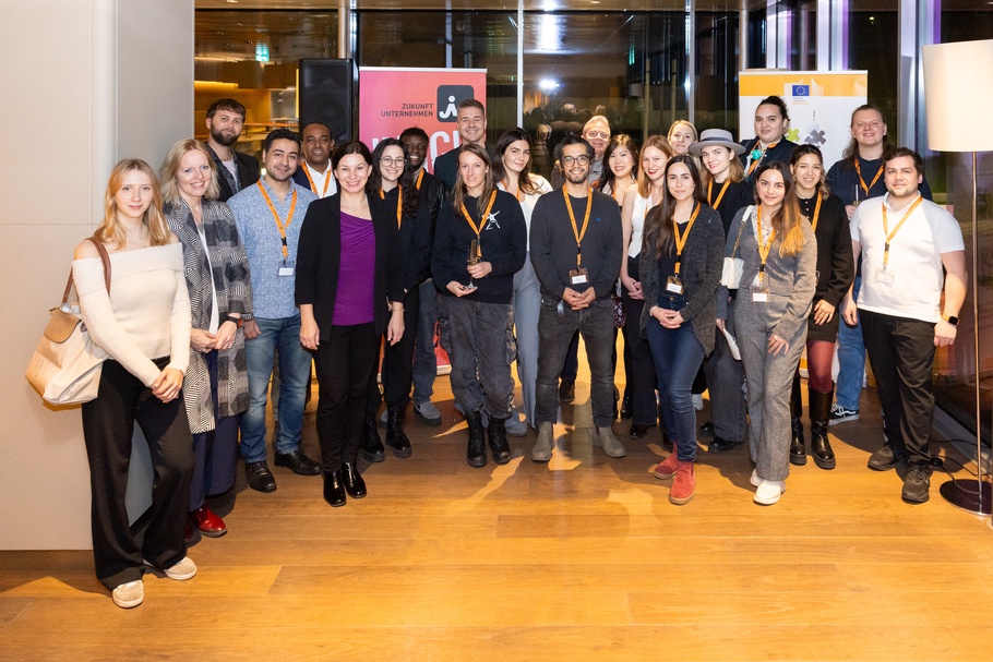 Zu sehen ist eine Gruppe von Menschen, einige von ihnen tragen Lenyards.