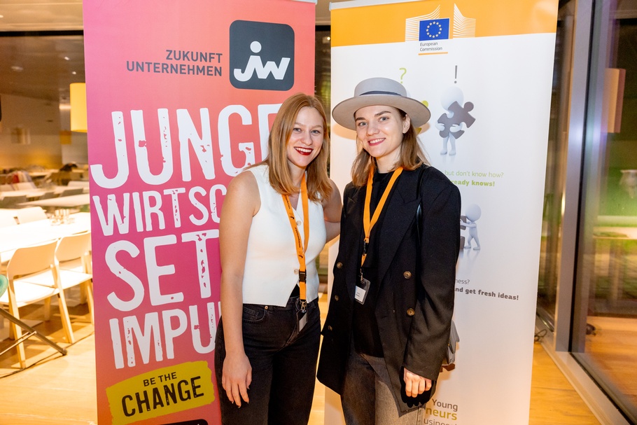 Zu sehen sind zwei Personen, die vor einem Roll-up stehen. Auf dieses ist "Junge Wirtschaft" gedruckt. 