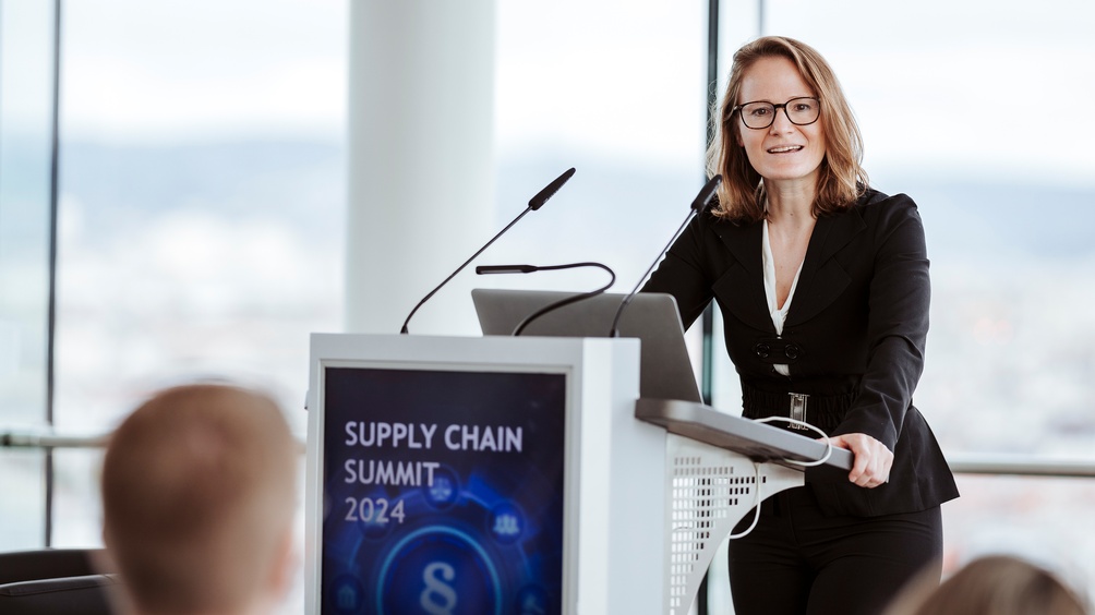 Person an Rednerpult stehend und sprechend