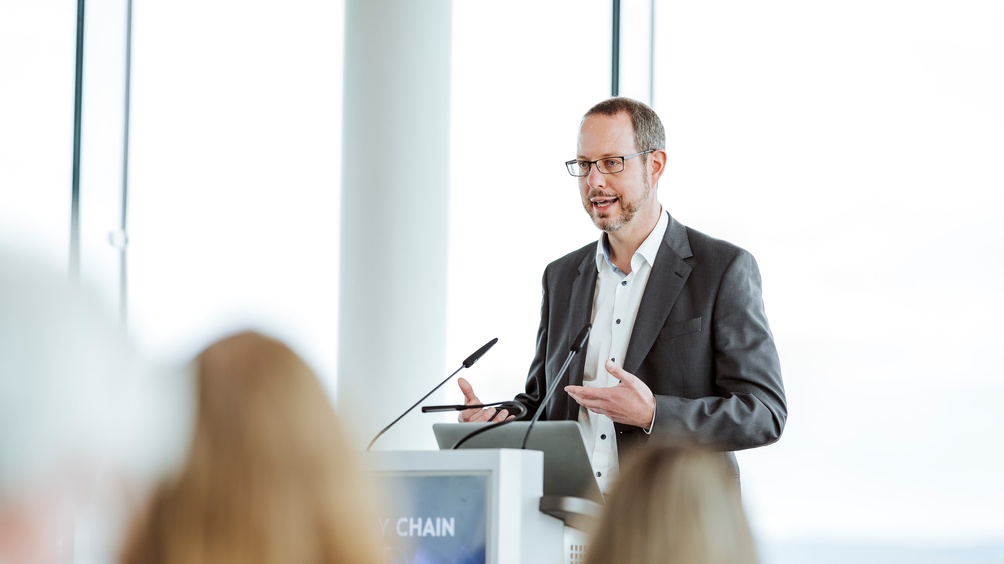 Person an Rednerpult stehend und sprechend