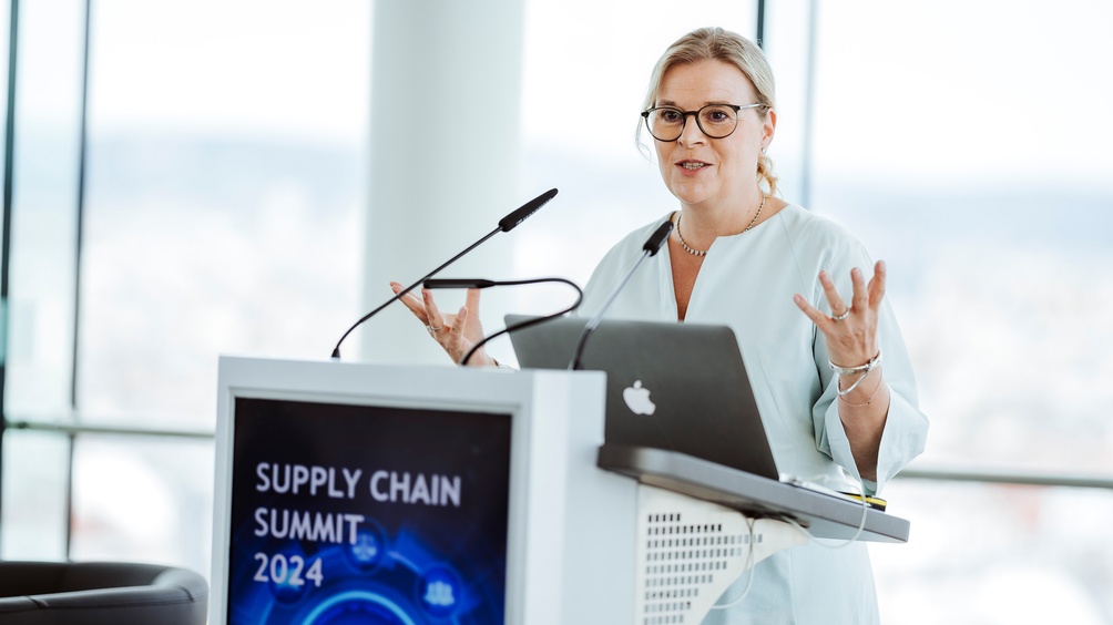 Person an Rednerpult stehend und sprechend