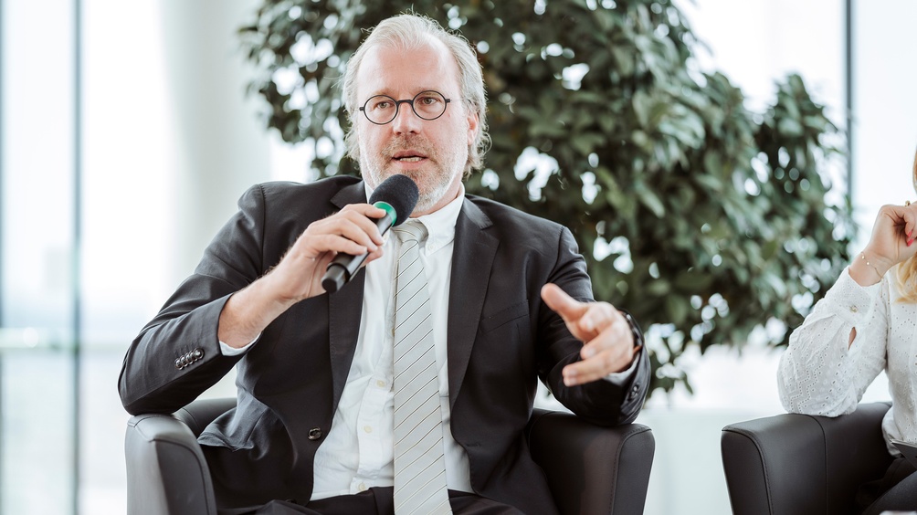 Sitzende Person spricht in Mikrofon