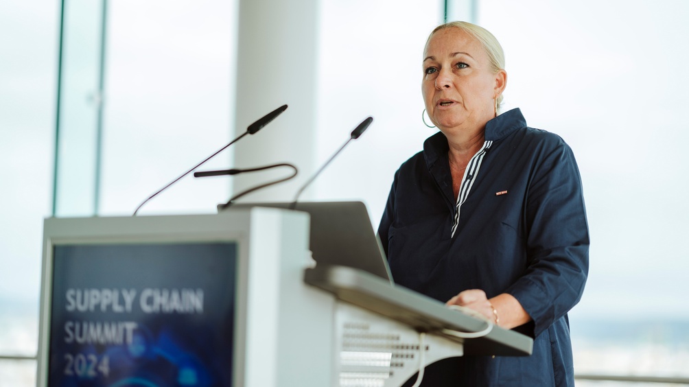 Person an Rednerpult stehend und sprechend