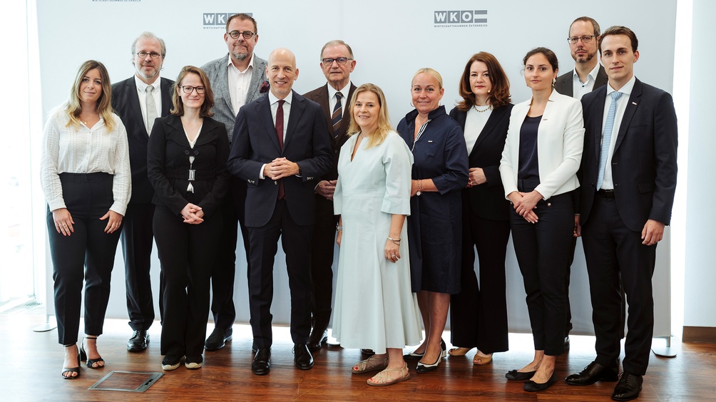 Mehrere Personen neben- und hintereinander stehend vor Wand mit Wirtschaftskammer Österreich-Logos