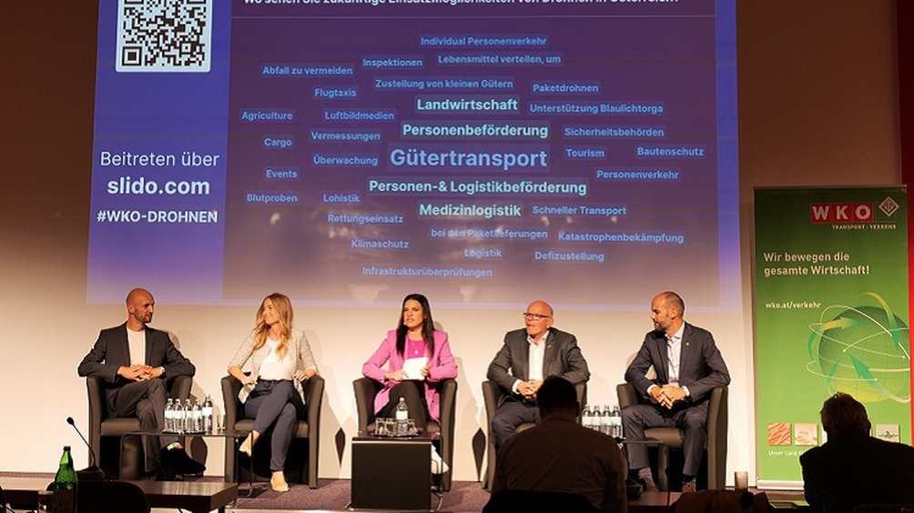 Menschen auf Podium bei Veranstaltung