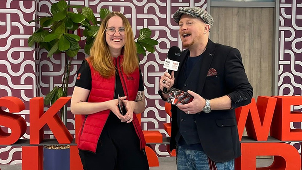 Zwei Personen sprechend, eine Mikrofon in der Hand