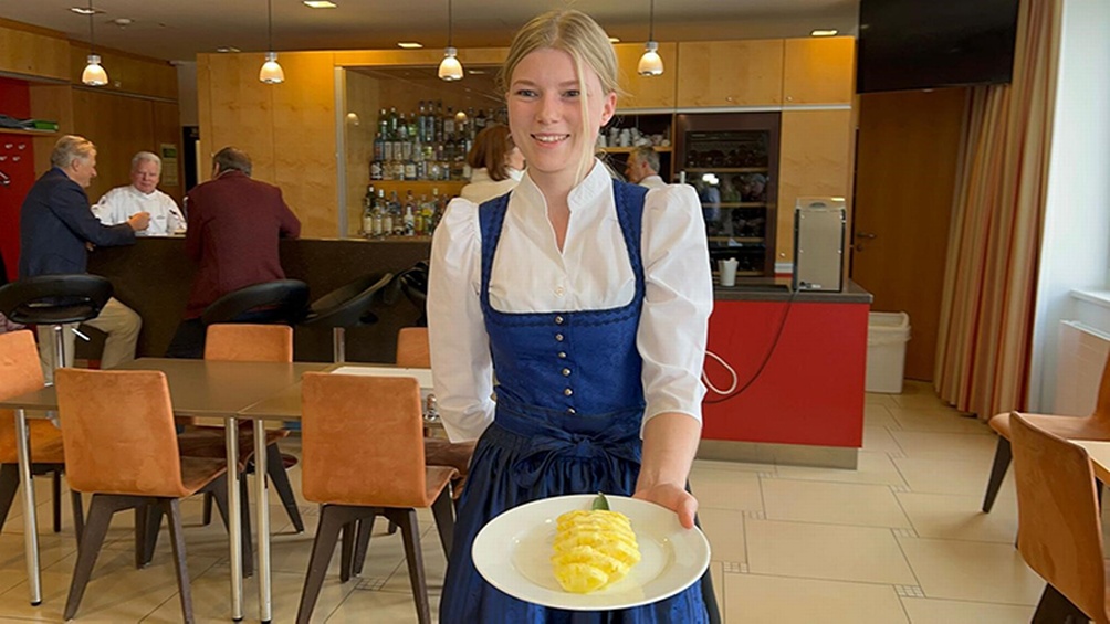 Person in Tracht serviert Speise