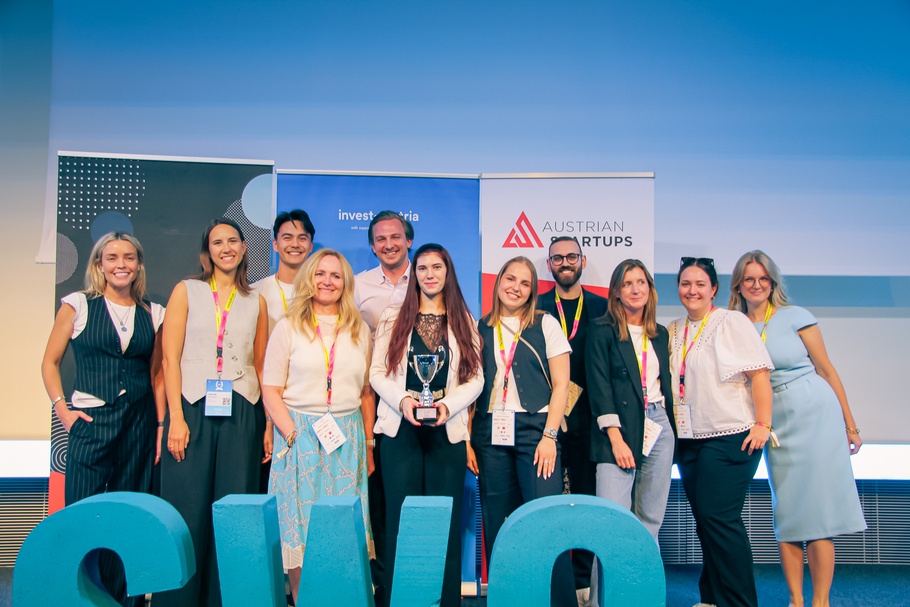 Personen stehen auf einer Bühne, hinter ihnen sind Roll-ups aufgestellt