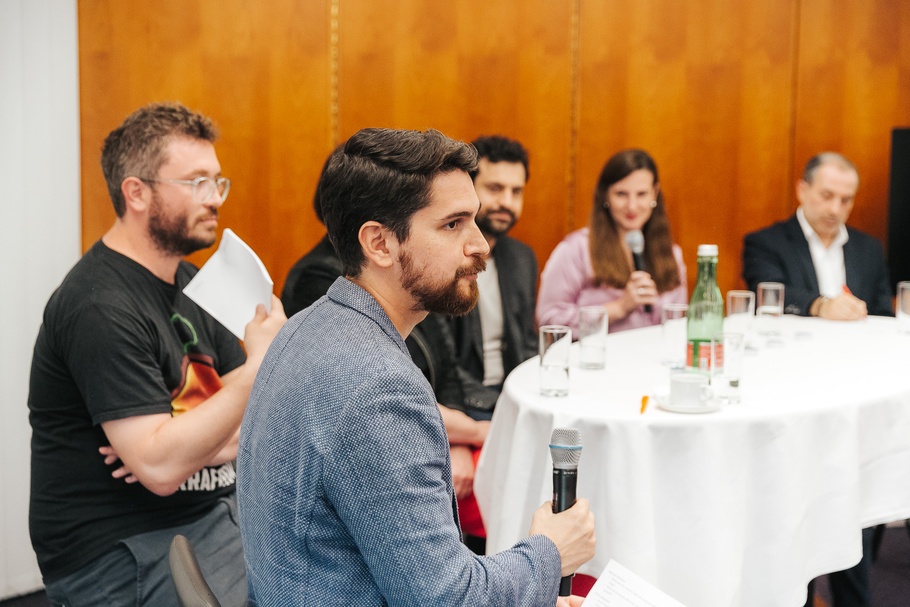 Verschiedene Teilnehmer:innen an einem Tisch