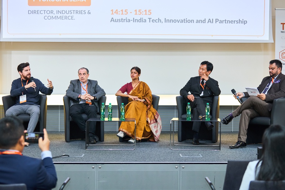 Menschen sitzen nebeneinander auf Sesseln auf einer Bühne 