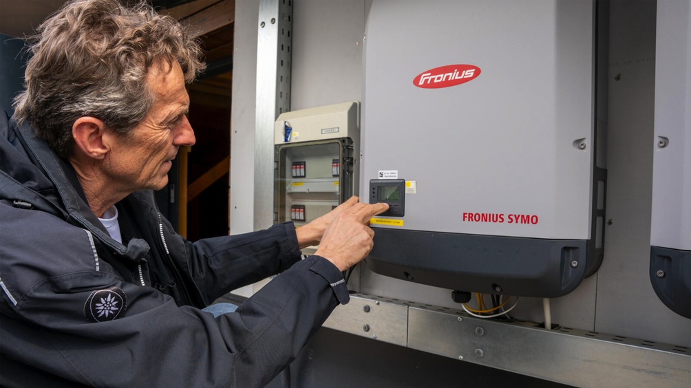 Person beim Bedienen einer PV-Anlage