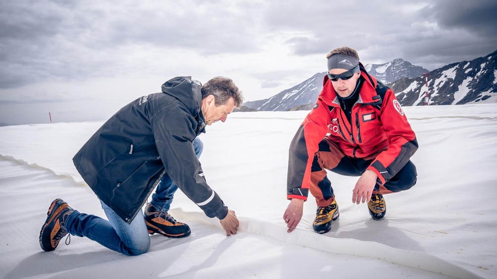 Zwei Menschen bei der Arbeit auf einer Piste