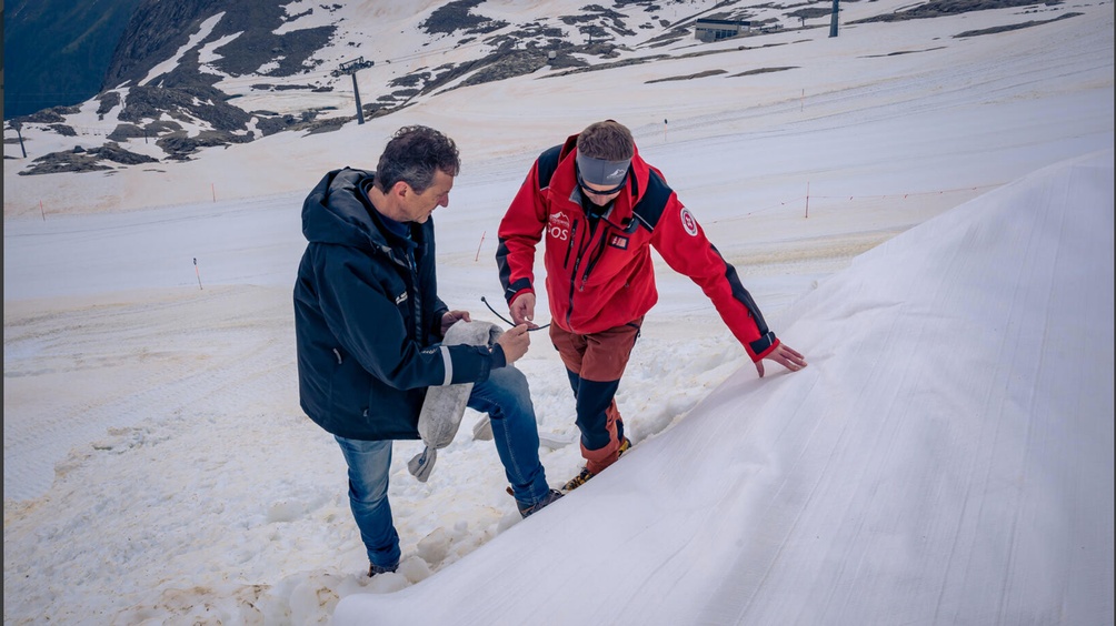 Zwei Menschen bei der Arbeit auf einer Piste