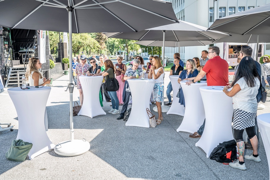Menschen im Freien die einem Vortrag lauschen