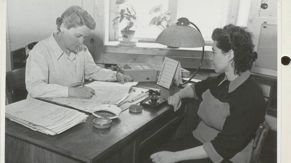 Beratung im Gesundheitsamt. Eine Frau sitzt der Oberfürsorgerin gegenüber.