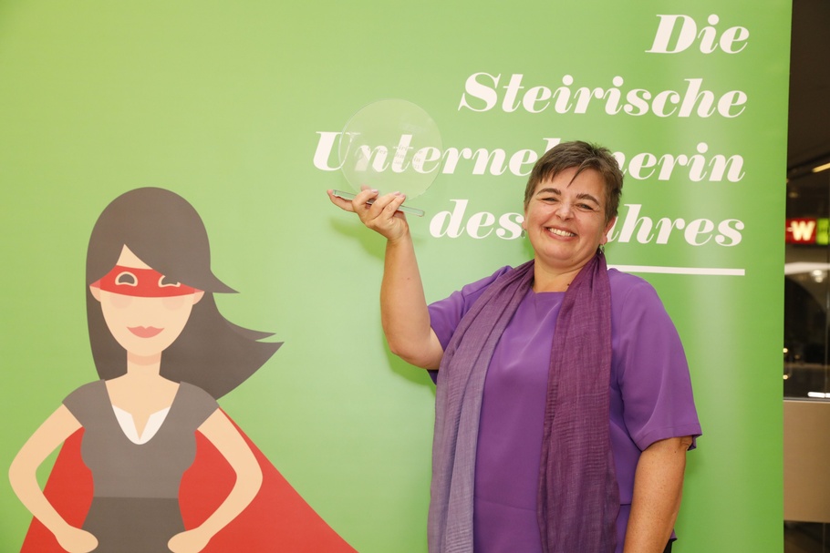 Beste Durchhalterin: Christina Domittner vor grünem Hintergrund mit dem Preis in der Hand