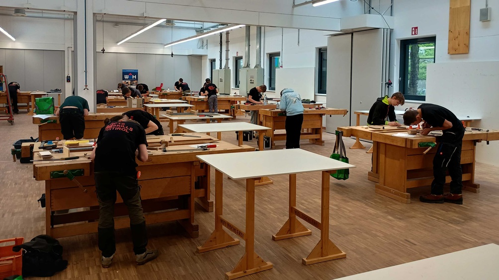 Blick in die WIFI-Tischlerhalle, an den Werkbänken arbeiten Jugendliche