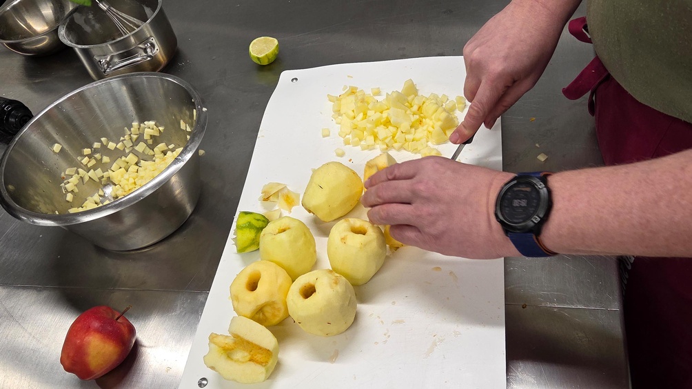 Nahaufnahme einer Hand, die Äpfel schneidet