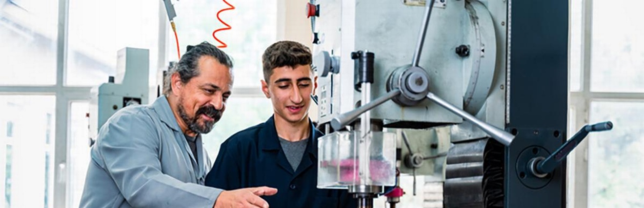 Lehrling an der Maschine mit Lehrlingswarth