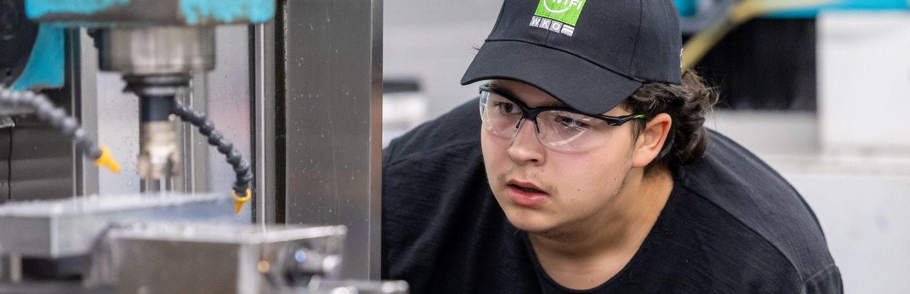 Der junge Goldmedaillengewinner bei der Arbeit vor einer großen Maschine