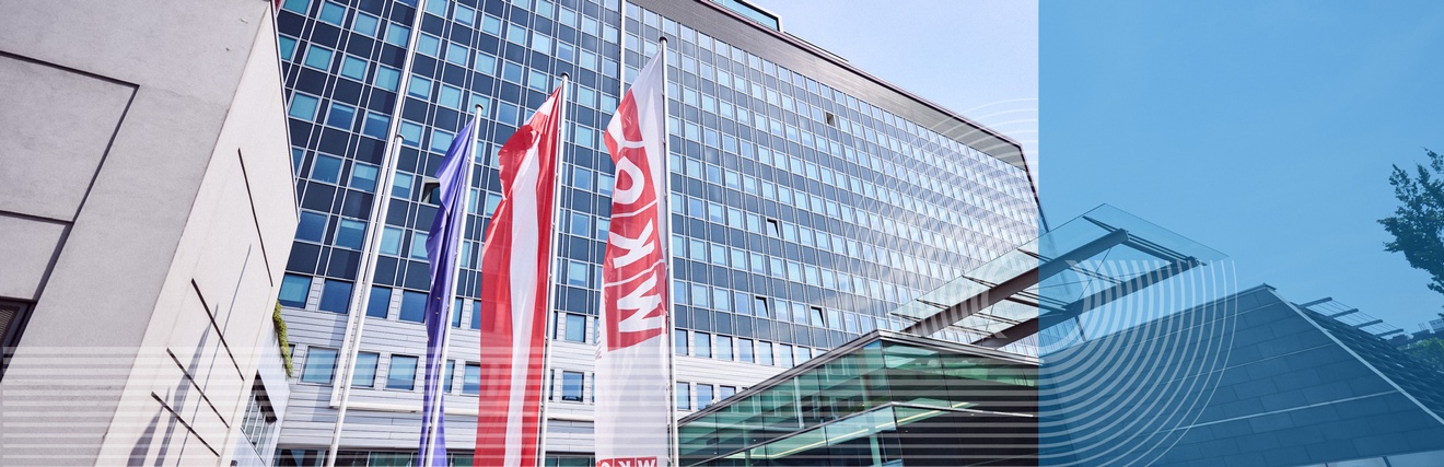 Außenansicht Gebäude der Wirtschaftskammer Österreich mit Österreich und EU Fahne vor blauem Himmel