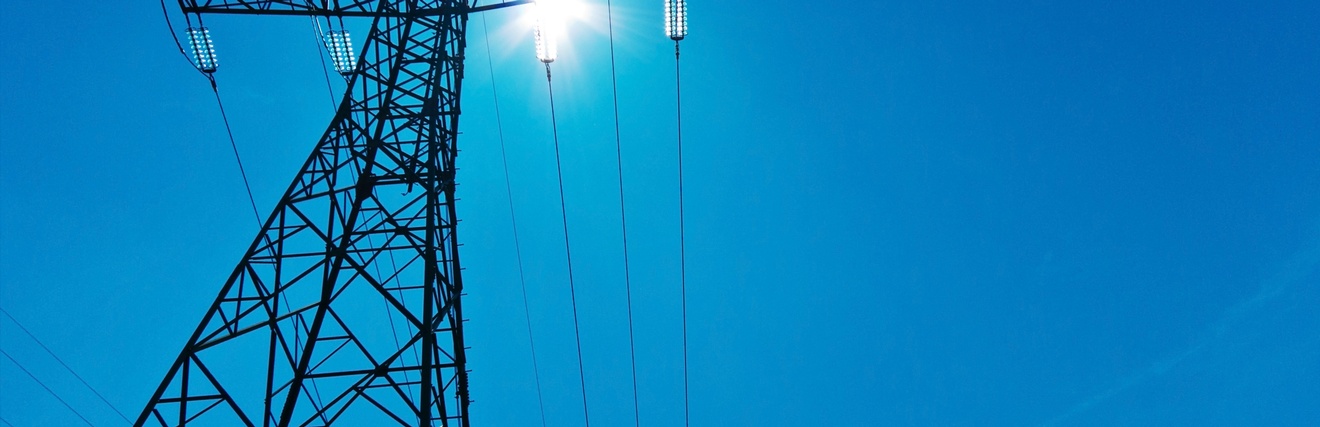 Ein Strommast mit Leitungen unter blauem Himmel