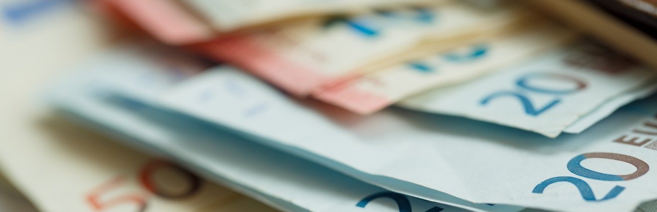 Nahaufnahme mehrerer, übereinander liegender Geldscheine, in der Höhe von einhundert, fünfzig, zwanzig und zehn Euro
