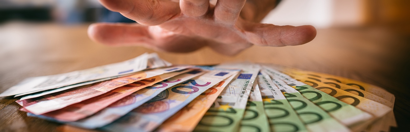 Hand über Geldscheinen