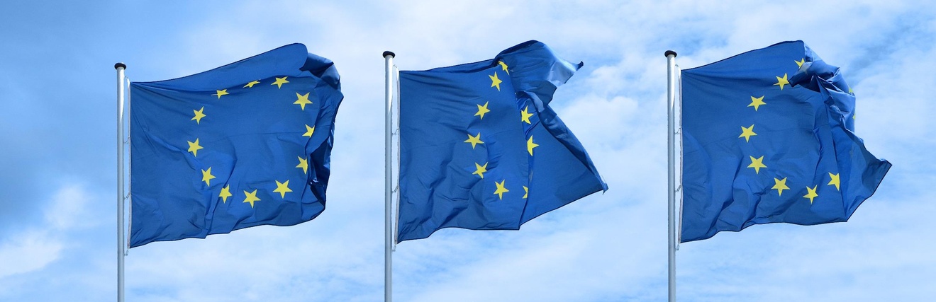 Drei EU-Flaggen flattern im Wind nebeneinander