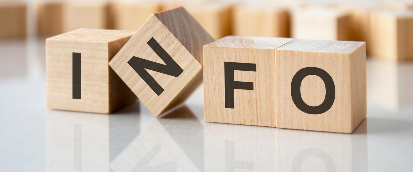 Holzwürfel mit Schriftzug Info, dahinter sind weitere Holzwürfel in der Unschärfe erkennbar