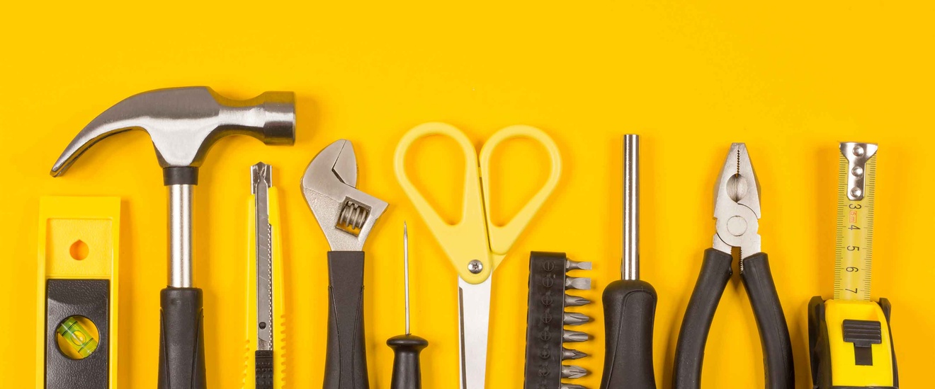 Verschiedene Werkzeuge vor einem gelben Hintergrund