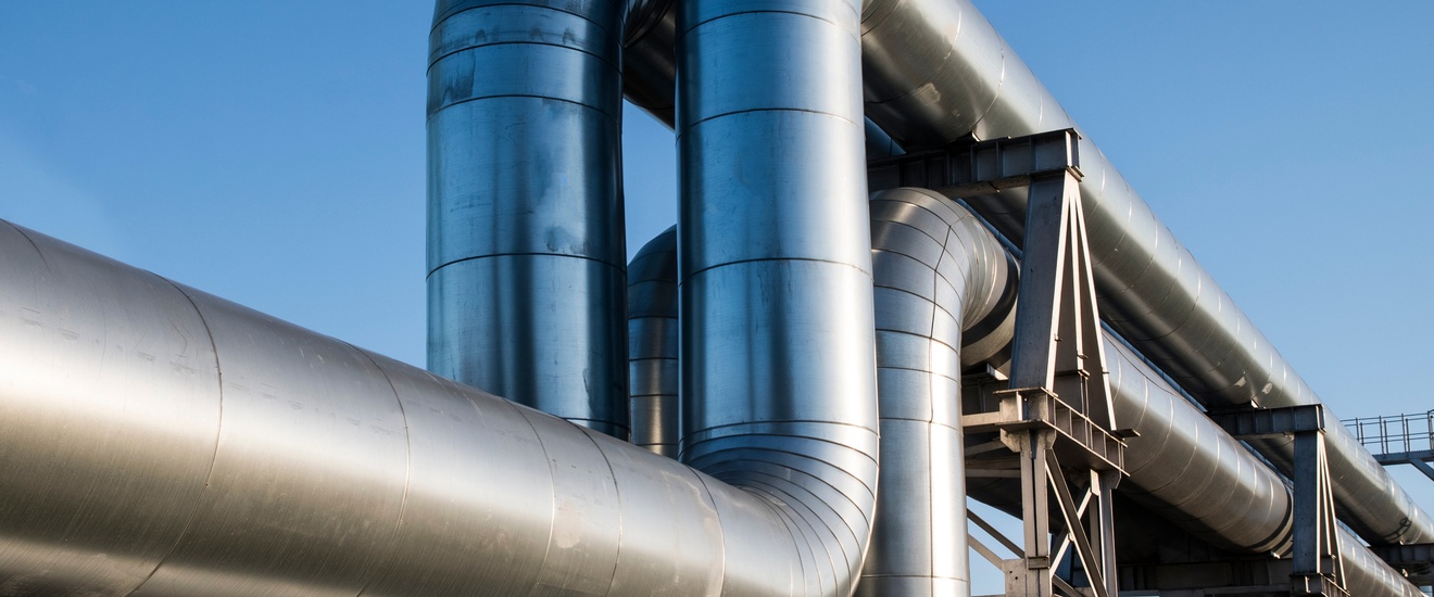 Zwei große Pipelines verlaufen parallel nebeneinander vor blauem Himmel