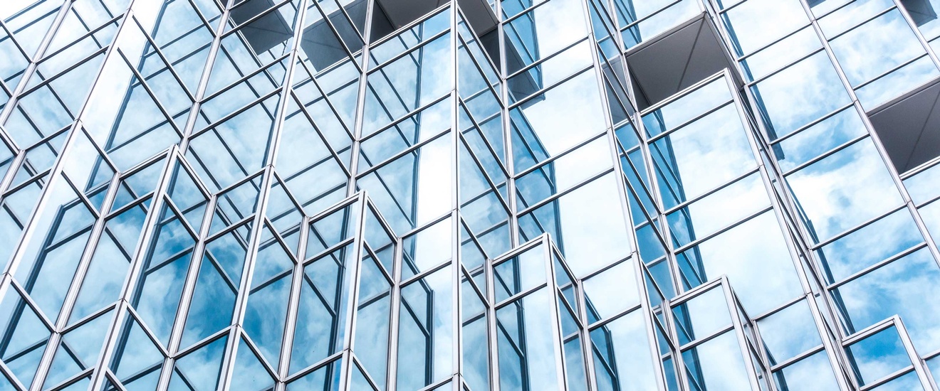 Perspektivansicht der Unterseite eines Hochhauses mit einet Stahl-Glas-Fassade