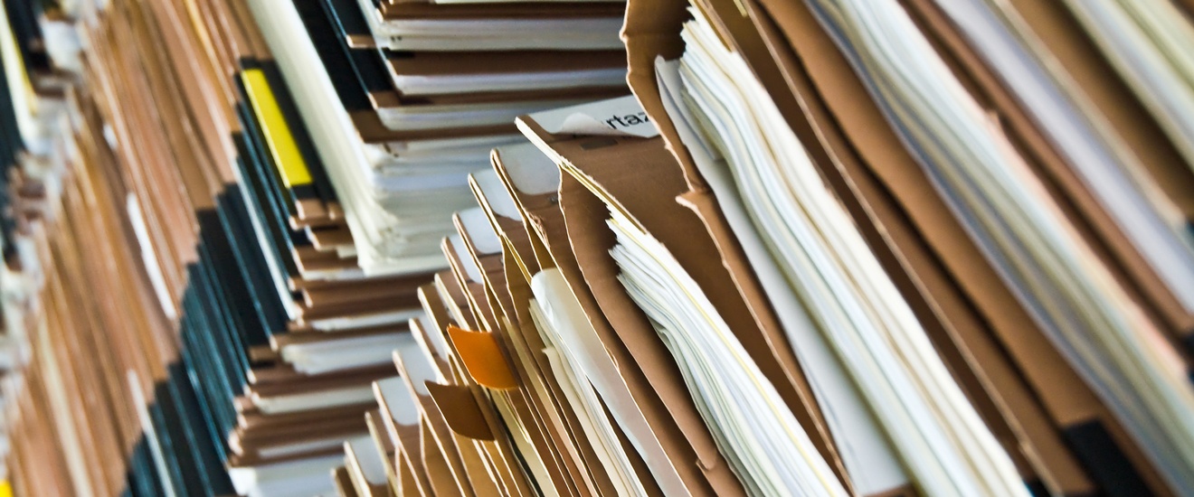Drei sehr hohe Aktenstapel nebeneinander
