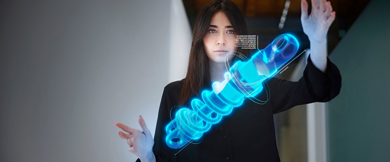 Person blickt auf Holographie einer blauen Spirale vor sich und hält beide Hände darum