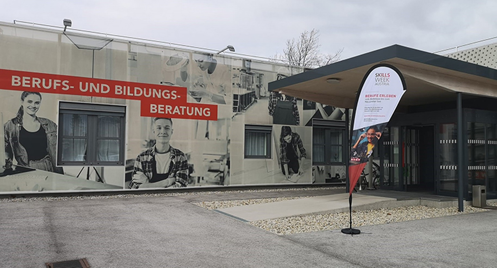 Eingangsbereich mit Fahne und großem Plakat zur Skills Week Austria