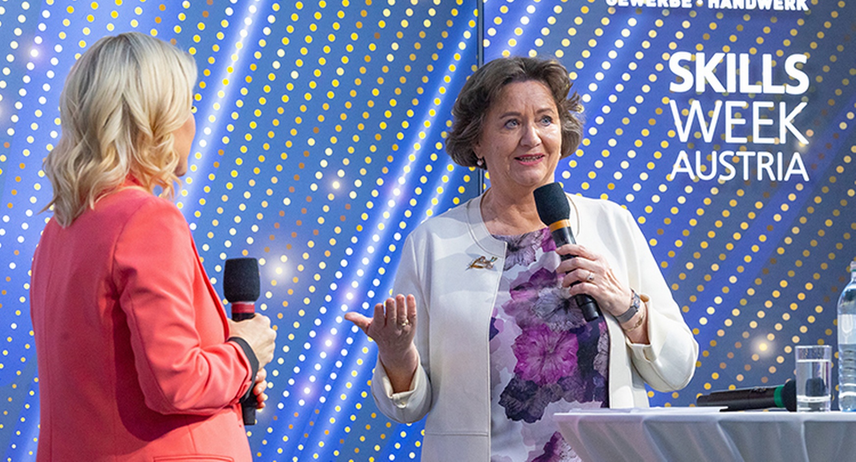 Person spricht in Mikrofon, im Hintergrund Schriftzug Skills Week Austria