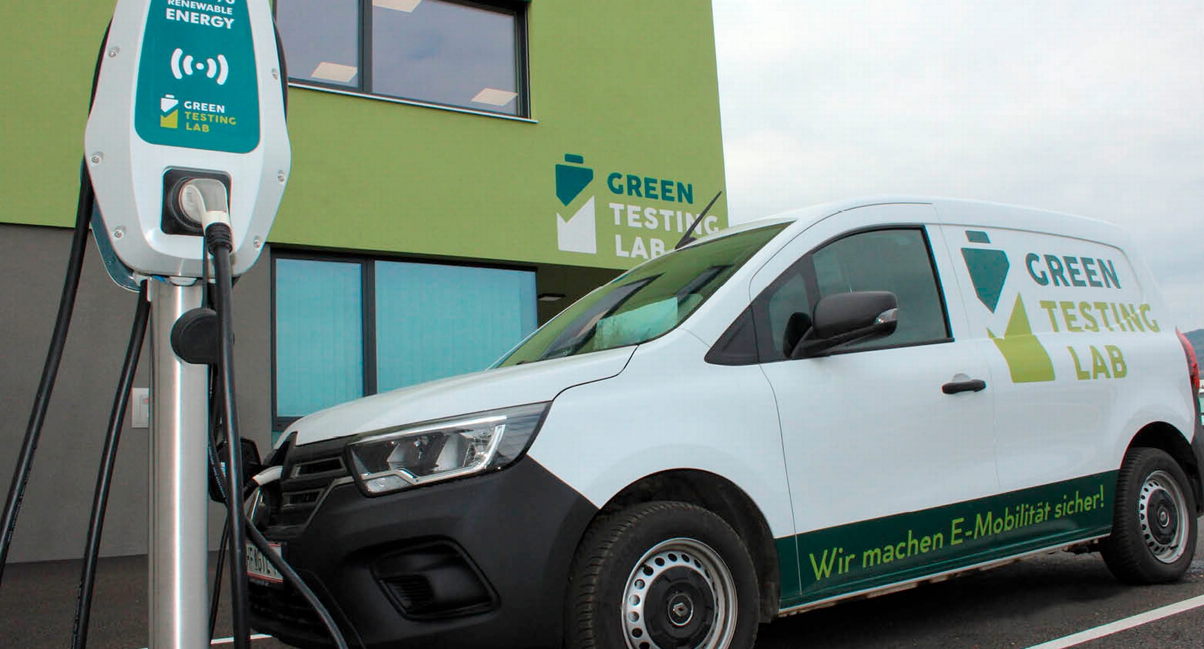 Blick auf ein E-Auto, an der Ladestation angeschlossen vor dem Green Testing Lab-Geb#ude