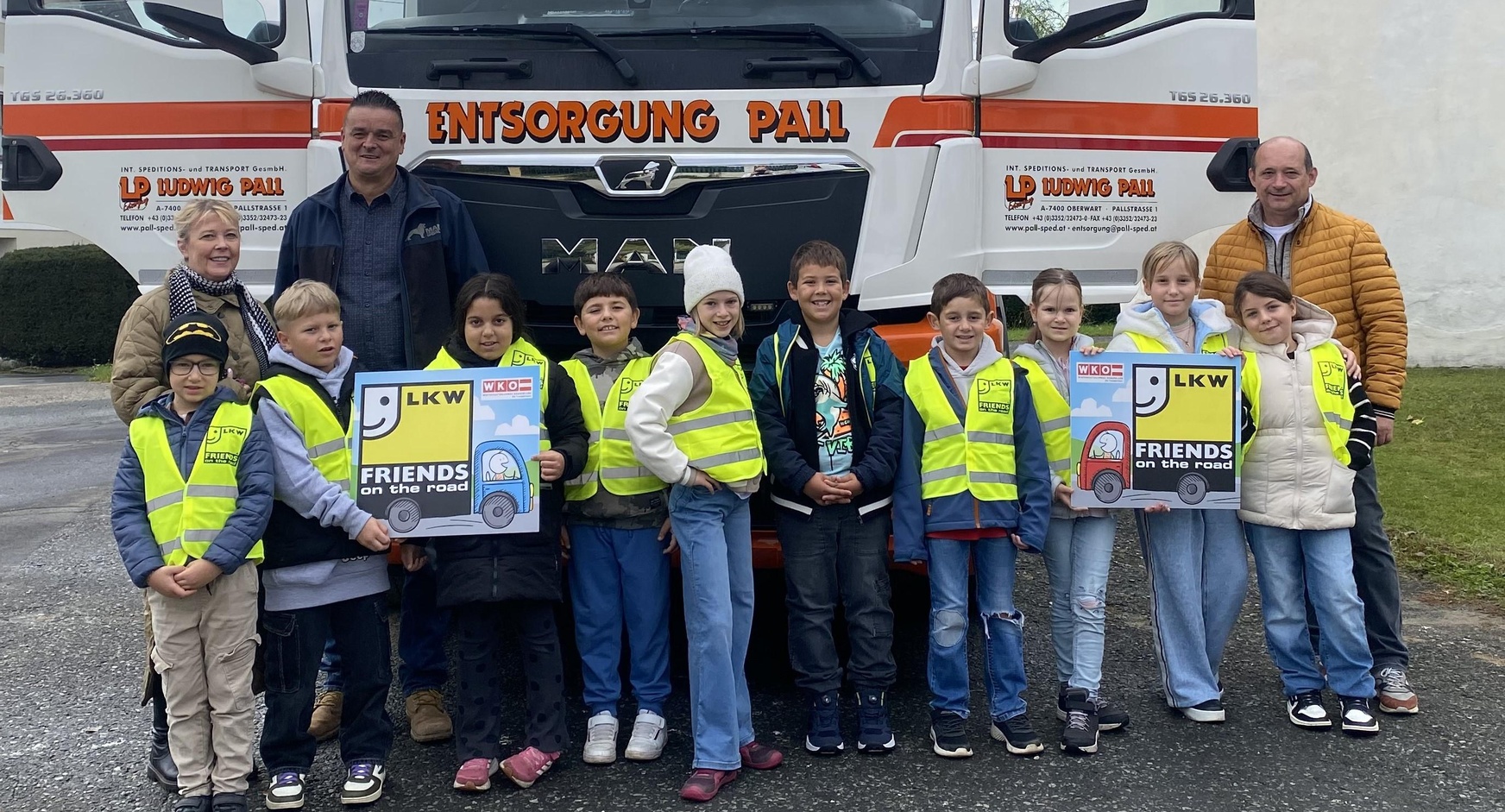 Klassenlehrerin Ursula Pasch, LKW-Fahrer Peter Varga und Direktor Wilhelm Miklos mit den Kindern der 3. und 4. Klasse der Volksschule Siget 
