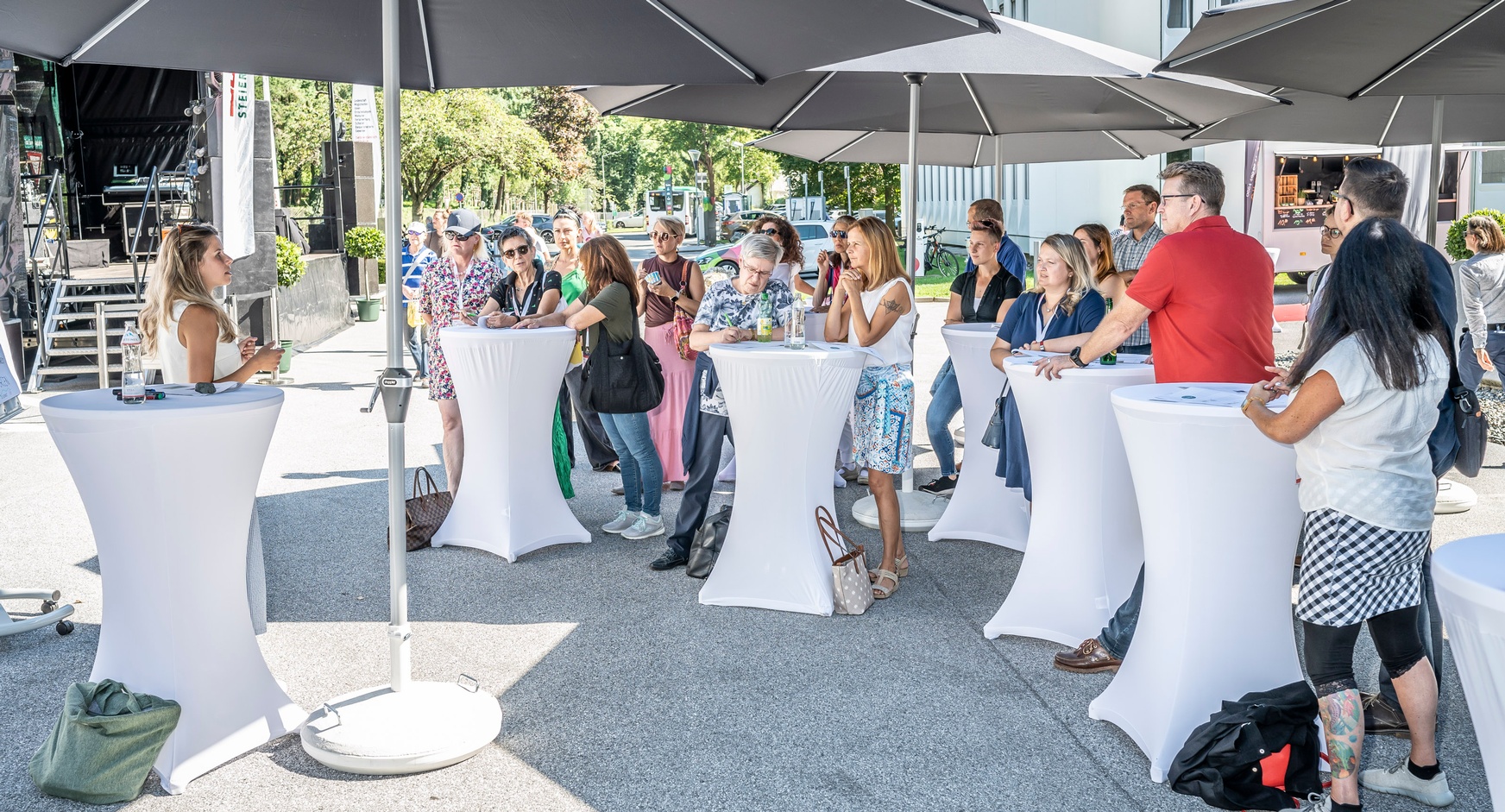 Menschen im Freien die einem Vortrag lauschen
