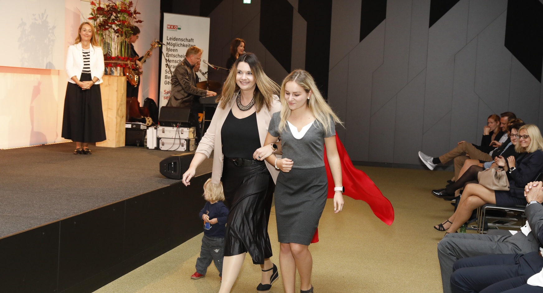 Unternehmerinnen gehen an der Bühne vorbei